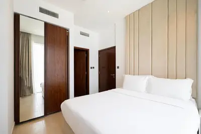 a bedroom with a large white bed and a mirror at Marina Gate One Bedroom Apartment in Dubai