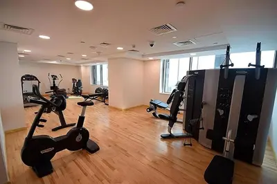 a gym with treadmills and exercise bikes in a room at Studio in JVC - Heart of Dubaï - Bloom Height in Dubai
