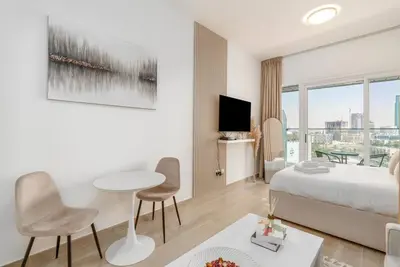 a hotel room with a bed and a table and chairs at Studio in JVC - Heart of Dubaï - Bloom Height in Dubai