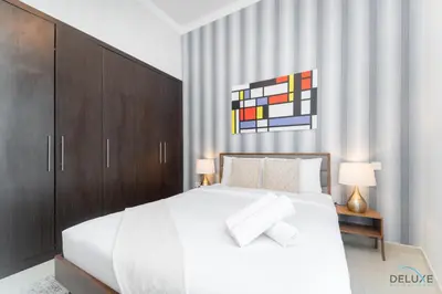a bedroom with a large white bed and wooden cabinets at Scenic 1BR at Bay Central 1 Dubai Marina by Deluxe Holiday Homes in Dubai