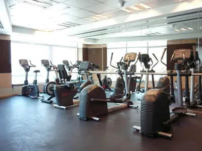 a gym with rows of exercise bikes and treadmills at Frank Porter - Bonaire Tower in Dubai