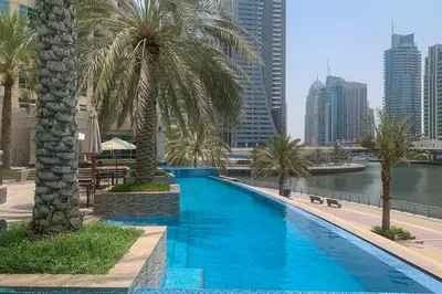 a swimming pool with palm trees and a city at Frank Porter - Bonaire Tower in Dubai