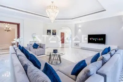 a living room with a large couch and a tv at Staycae Palm Jumeirah Villa in Dubai