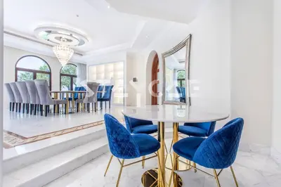 a dining room with a table and blue chairs at Staycae Palm Jumeirah Villa in Dubai