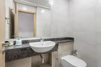 a bathroom with a sink and a toilet and a mirror at Spacious 1 bedroom in Business Bay - Close to Downtown in Dubai