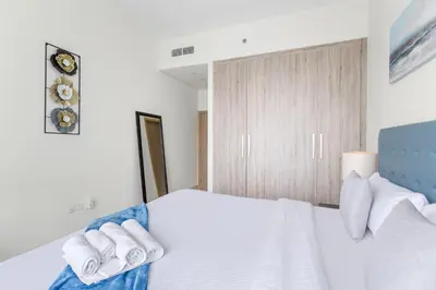 a bedroom with a white bed with towels on it at Spacious 1 bedroom in Business Bay - Close to Downtown in Dubai