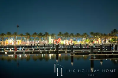 a view of a marina at night with palm trees at LUX The Dubai Creek View Suite in Dubai