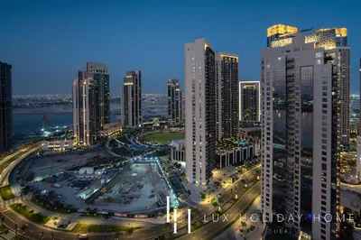 a city skyline at night with tall buildings at LUX The Dubai Creek View Suite in Dubai