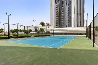 a tennis court in front of a large building at 2bdr Emaar The Grand - Sea View - Creek Harboor in Dubai