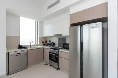 a kitchen with a stainless steel refrigerator and a sink at 2bdr Emaar The Grand - Sea View - Creek Harboor in Dubai