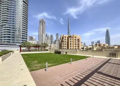 a park in the middle of a city with tall buildings at Trophy - Downtown Skyline Sanctuary Suite in Dubai