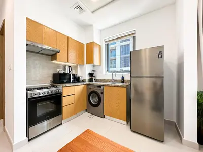 a kitchen with a stainless steel refrigerator and a dishwasher at Trophy - Downtown Skyline Sanctuary Suite in Dubai