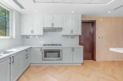 a kitchen with white cabinets and a stove top oven at Private villa in Dubai with swimming pool and huge garden in Dubai