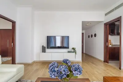 a living room with a vase of blue flowers on a table at Frank Porter - Beauport in Dubai