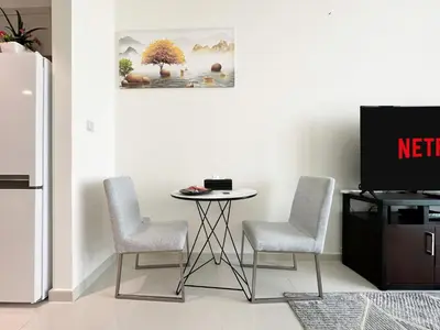 a kitchen with a table and two chairs and a tv at Trophy - Urban Escape Suite in Dubai