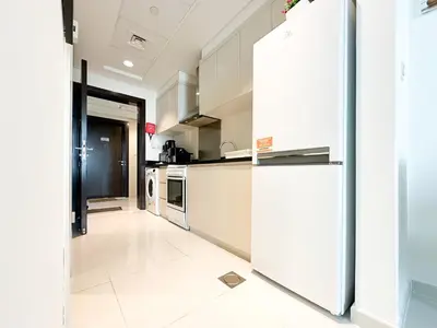 a kitchen with white appliances and a refrigerator at Trophy - Urban Escape Suite in Dubai