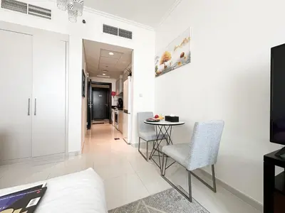 a white living room with a table and chairs at Trophy - Urban Escape Suite in Dubai