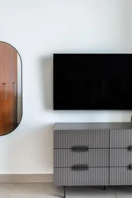 a living room with a television on a white wall at The Smart Concierge - Burjvista in Dubai