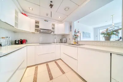 a white kitchen with white cabinets and a window at Fairfield Tower, Park Island, Dubai Marina - Mint Stay in Dubai