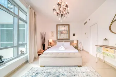 a bedroom with a large bed and a chandelier at Fairfield Tower, Park Island, Dubai Marina - Mint Stay in Dubai