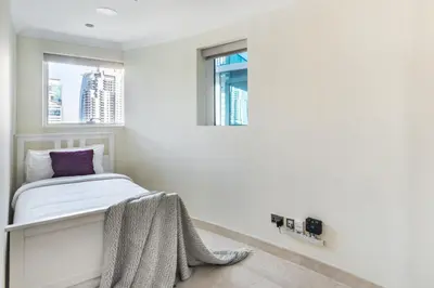 a white room with a bed and a window at The Smart Concierge - Marinascape Oceanic in Dubai