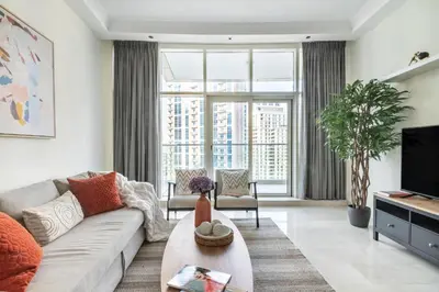 a living room with a couch and a tv at The Smart Concierge - Marinascape Oceanic in Dubai