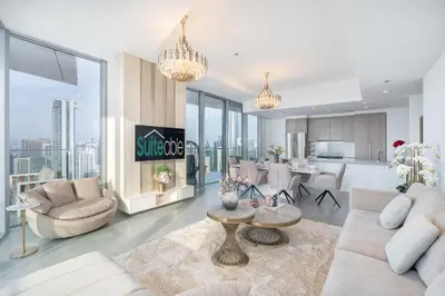 a living room with white furniture and a kitchen at Luxurious 3BR Apartment with Panoramic Marina View in Dubai