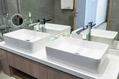 a bathroom with two white sinks and a mirror at Luxurious 3BR Apartment with Panoramic Marina View in Dubai