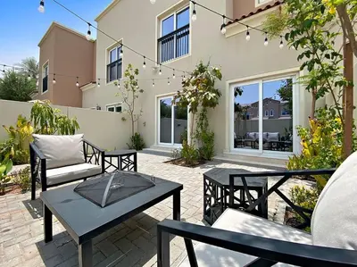 a patio with tables and chairs in front of a building at Luxurious 3BR Villa Amaranta in Dubai