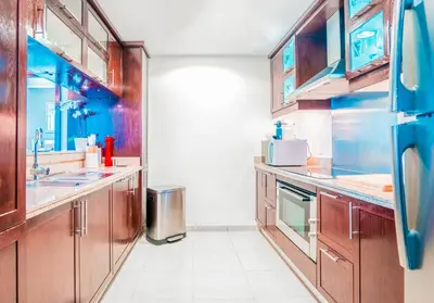 a large kitchen with wooden cabinets and appliances at Elite Royal Apartment - Full Burj Khalifa & Fountain View - Highness in Dubai