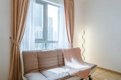 a couch in a room with a large window at INA Homes-Tower 5 Perfect Burj Khalifa and Fountain Views in Dubai