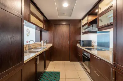 a large kitchen with wooden cabinets and a sink at INA Homes-Tower 5 Perfect Burj Khalifa and Fountain Views in Dubai