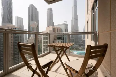two chairs and a table on a balcony with a view of the city at INA Homes-Tower 5 Perfect Burj Khalifa and Fountain Views in Dubai