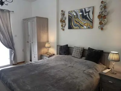 a bedroom with a large bed and a painting on the wall at Diamond 2 Tower Marina Apartment in Dubai