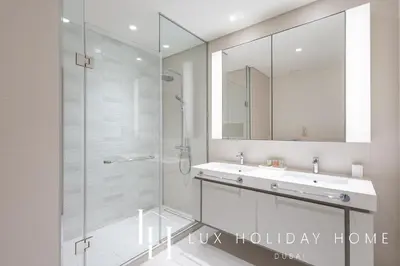 a bathroom with a shower and a sink and a mirror at LUX The Ultimate Palm Sea Skyline Penthouse in Dubai