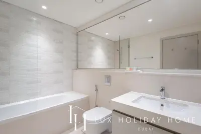 a bathroom with a sink and a tub and a mirror at LUX The Ultimate Palm Sea Skyline Penthouse in Dubai