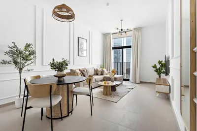 a living room with a table and a couch at Silkhaus modern 1BDR in Belgravia Heights with pool & gym in Dubai