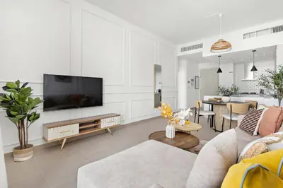 a living room with a couch and a tv at Silkhaus modern 1BDR in Belgravia Heights with pool & gym in Dubai