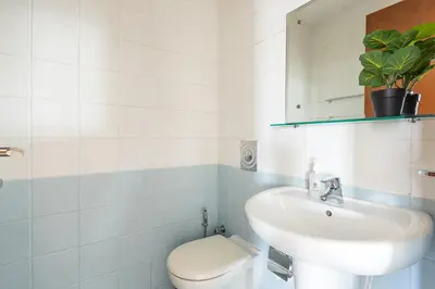 a white bathroom with a sink and a toilet at Frank Porter - MAG214 in Dubai