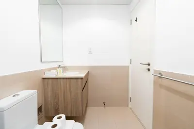 a white bathroom with a toilet and a sink at Nice 1Bedroom - UNA Townsquare in Dubai