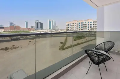 two chairs on a balcony with a view of a city at Silkhaus spacious studio in Art Gardens with gym & pool access in Dubai
