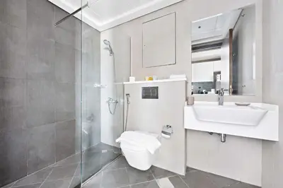 a bathroom with a toilet and a sink and a shower at Silkhaus spacious studio in Art Gardens with gym & pool access in Dubai