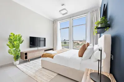 a bedroom with a bed and a large window at Silkhaus beautiful studio in Art Gardens with pool access in Dubai