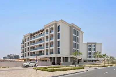 a white building with a car parked in front of it at Silkhaus new studio in Art Gardens pool access in Dubai