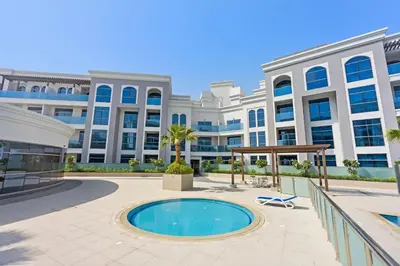 a large building with a pool in front of it at Silkhaus new studio in Art Gardens gym & pool access in Dubai
