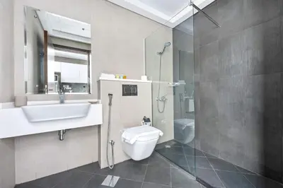a bathroom with a toilet and a sink and a shower at Silkhaus exquisite studio in Art Gardens with gym access in Dubai