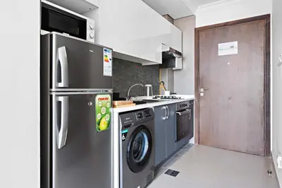 a kitchen with a stainless steel refrigerator and a dishwasher at Silkhaus Chic Studio in Art Gardens Modern Living in Dubai