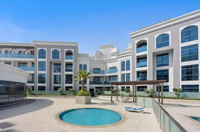 a large white building with a pool in front of it at Silkhaus Chic Studio in Art Gardens Modern Living in Dubai