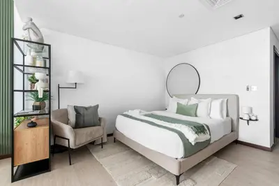 a bedroom with a large bed and a chair at Silkhaus modern studio in Liberty House in Dubai