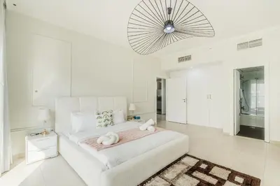 a white bedroom with a large bed and a chandelier at RH- Urban Living, spacious 01BR, near burj Khalifa in Dubai